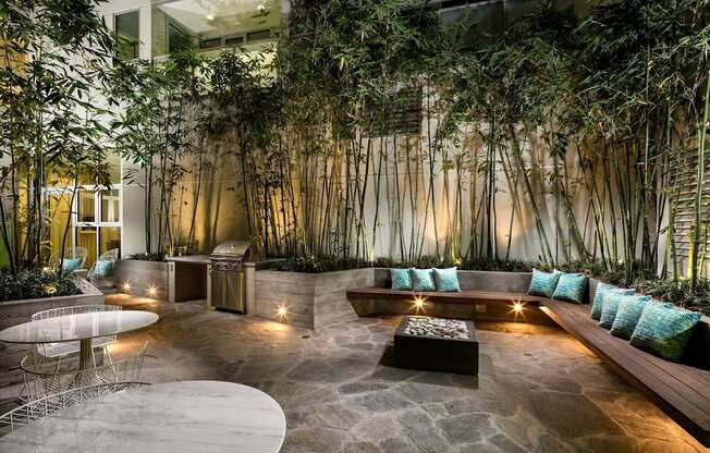A modern outdoor seating area with a stone floor and a wall of hanging plants.