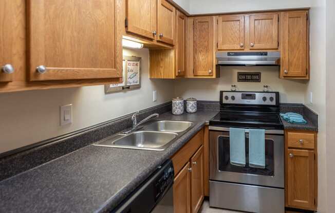 a kitchen with granite counter tops and stainless steel appliances and wooden cabinets