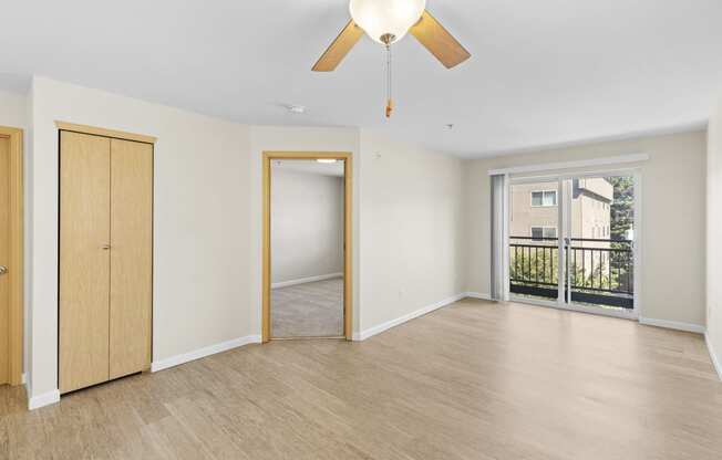 View from the Living Space with a ceiling fan of the wide windows and cozy bedroom at Promenade at the Park Apartment Homes, Seattle, Washington 98125