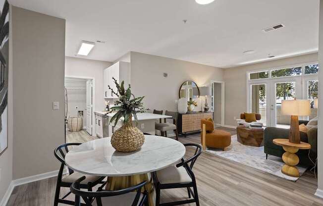 Flatiron West Trade Apartments staged model unit kitchen connected to living room with stainless steel modern appliances and quartz countertops