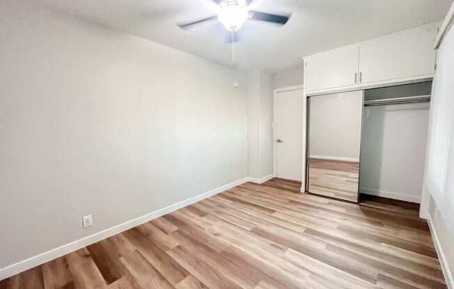 an empty living room with wood flooring and a closet