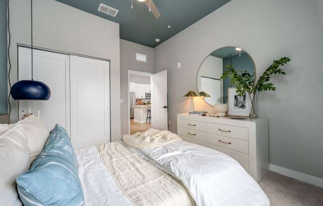 a bedroom with a bed and a dresser with a mirror