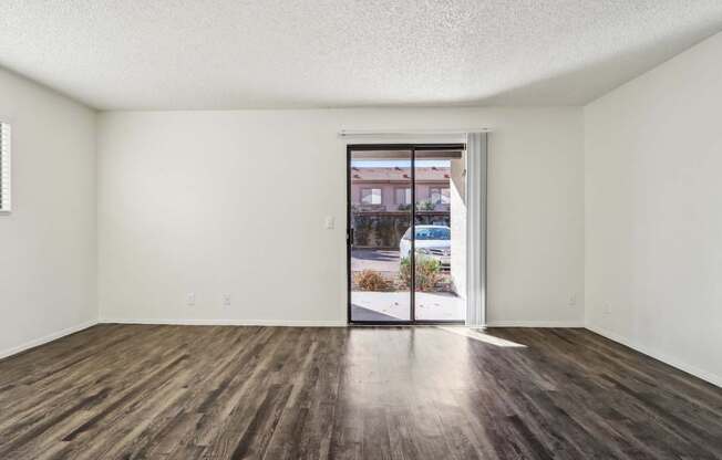 A room with a sliding glass door leading to a street.