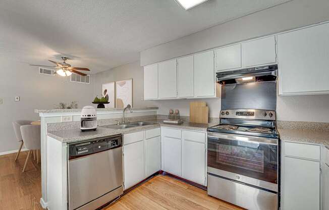 A modern kitchen with stainless steel appliances and white cabinets.