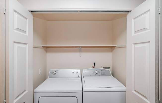 a washer and dryer in a laundry room with white doors