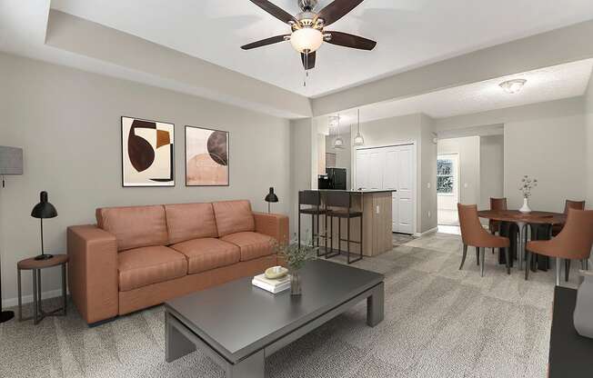 A living room with a brown couch, a grey coffee table, and a ceiling fan at Lynbrook Apartments and Townhomes, Elkhorn, NE, 68022