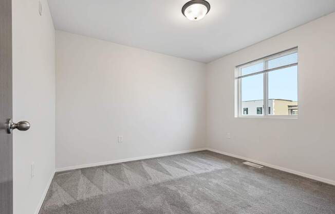 A room with a carpeted floor and a window.