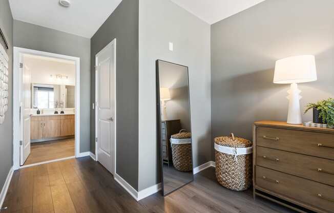 a hallway with a mirror and a dresser and a bathroom