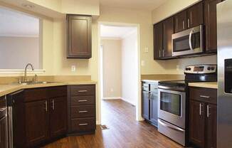 a kitchen with wooden floors and stainless steel appliances