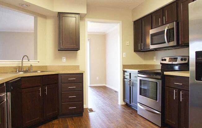 a kitchen with wooden floors and stainless steel appliances