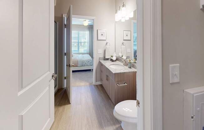 an ensuite bathroom with luxury vinyl plank flooring and a walk-in shower