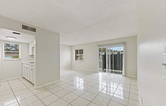 an empty living room with a sliding glass door to a patio