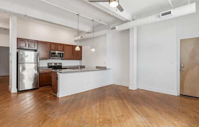 A kitchen with a refrigerator, microwave, and oven.