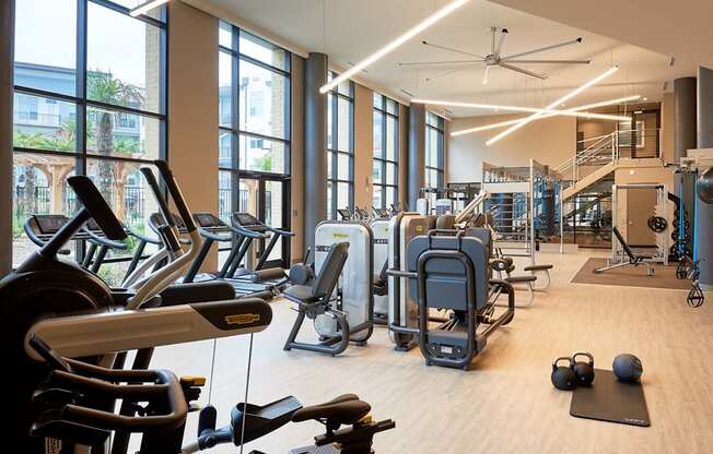 A gym with treadmills, exercise bikes, and weights.