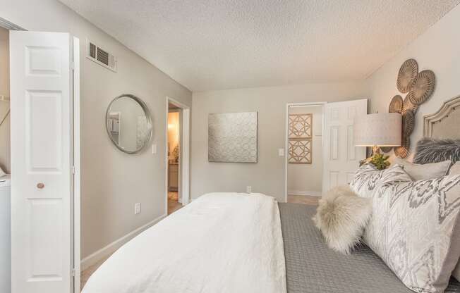 a bedroom with a large bed and a door to a bathroom at Lodge of Overland Park Apartments, Kansas