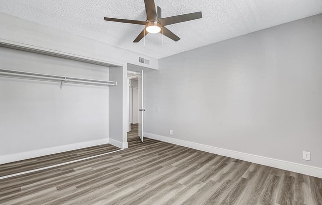 a bedroom with a ceiling fan and a closet with a sliding door