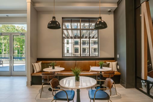 a seating area with tables and chairs and a window