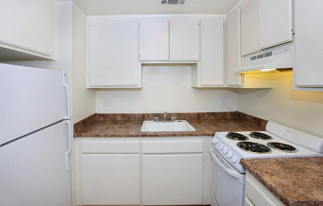 a kitchen with a white stove top oven sitting inside of a refrigerator