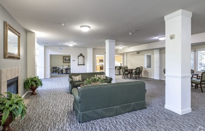 A living room with a grey couch and a fireplace.