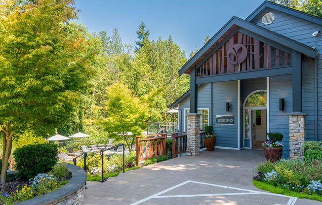 a patio in front of a blue building with a porch