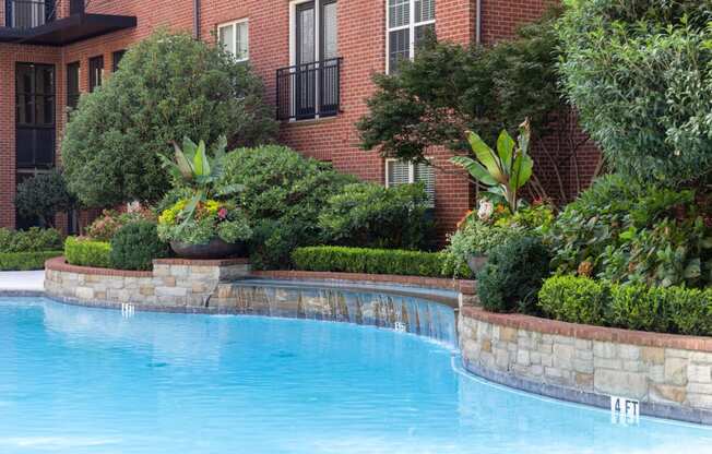 a swimming pool in front of a brick building