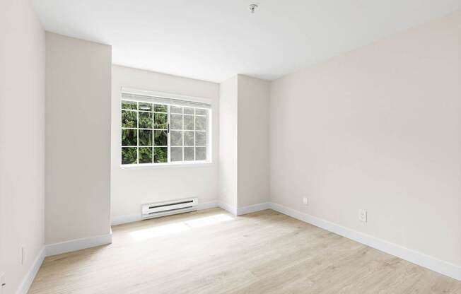 A room with a window and a wall-mounted air conditioner.