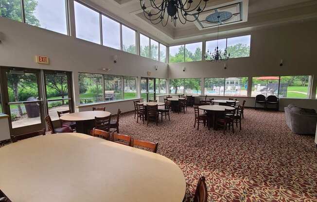 A large room with tables and chairs and a chandelier.