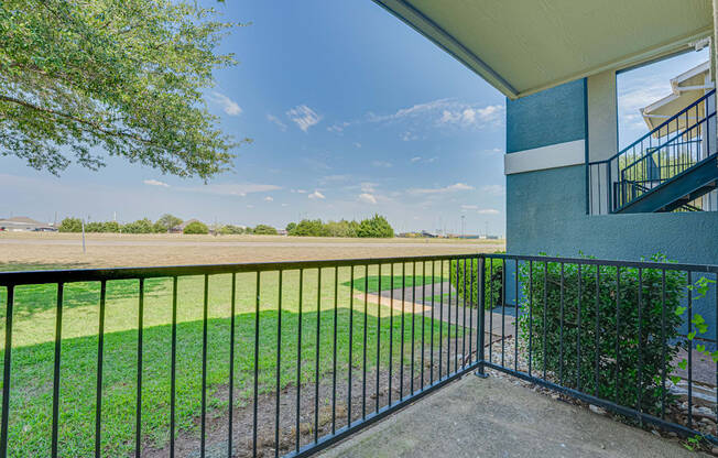 A black metal fence surrounds a green lawn.
