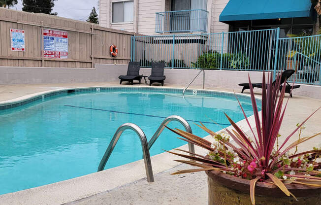 Swimming pool and chaise lounge chairs at La Mesa Village Apartments in La Mesa, California.