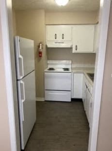 a kitchen with white appliances and a refrigerator