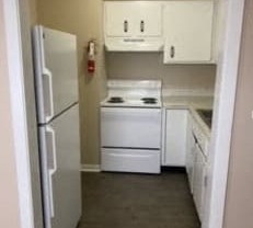 a kitchen with white appliances and a refrigerator