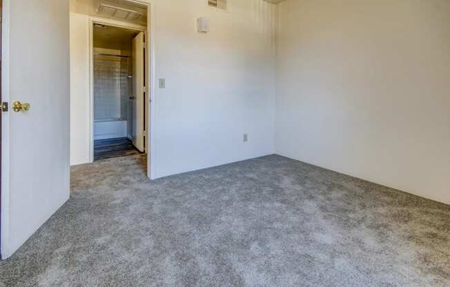 a room with carpet and a door to a bathroom
