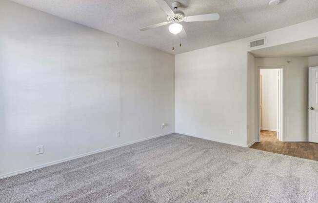 Another view of the spacious bedroom at Saxony at Chase Oaks Apartments in Dallas, TX, with a walk-in closet and ceiling fan.