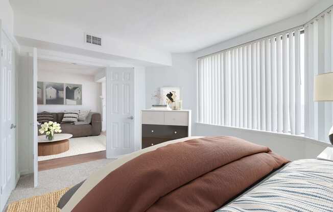 a bedroom with a bed and a living room with a couch