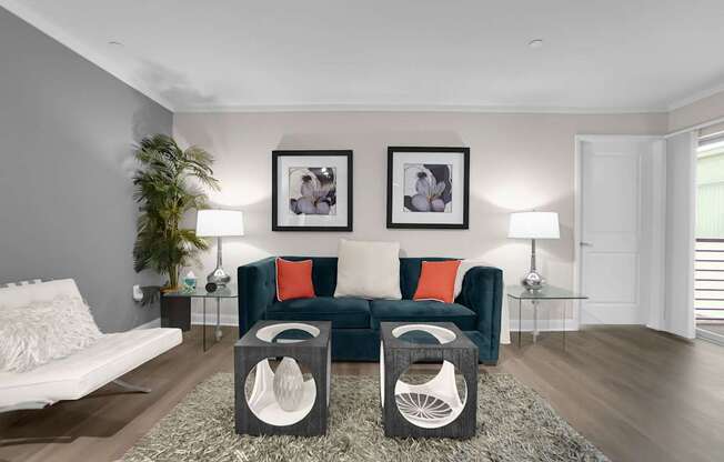 A living room with a green couch and two framed pictures on the wall.