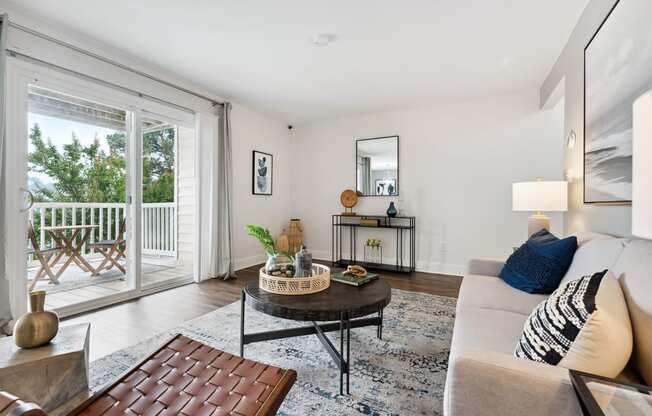 a living room with a sliding glass door that leads to a balcony at Linkhorn Bay Apartments, Virginia Beach, VA