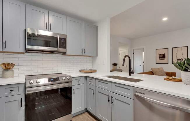 A modern kitchen with a stainless steel oven and microwave.