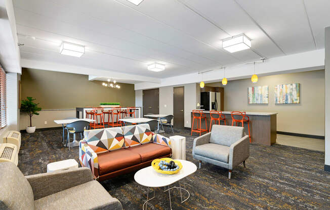 A room with a couch, chairs, and a table.