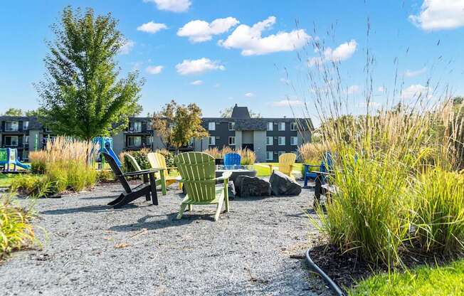 A gravel area with chairs and a table in front of a building.