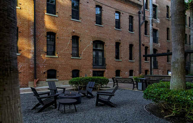 A courtyard with a table and chairs surrounded by brick buildings.