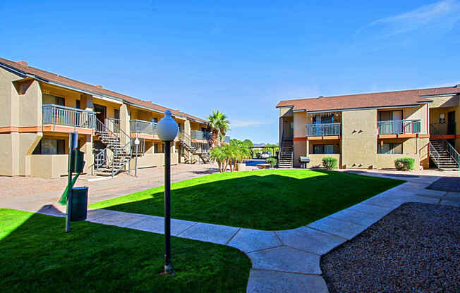 an exterior view of apartments with a yard and grass