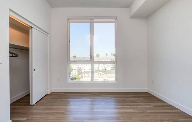 a living room with a large window and wooden floors
