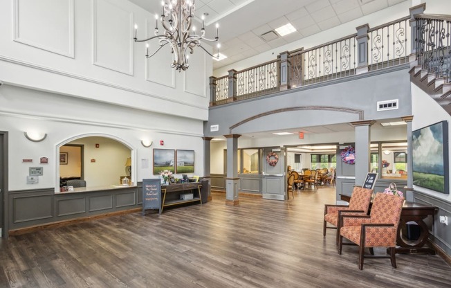 a lobby with chairs and a reception desk and a chandelier