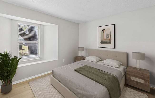 A bedroom with a large bed, a potted plant, and a framed picture on the wall.