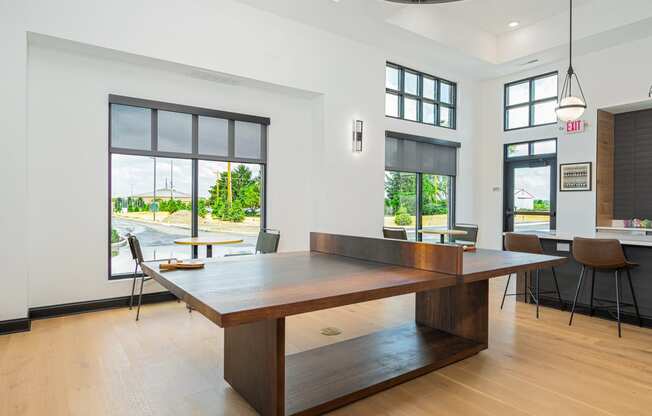 a dining room with a large table and chairs and windows