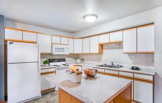 a kitchen with white appliances and wooden cabinets