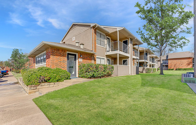 A brick house with a green lawn in front.