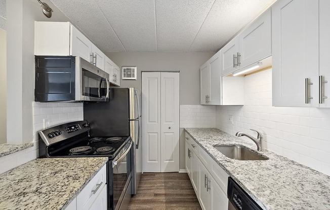 kitchen with white cabinets and granite counter tops at Troy Place Apartments - Troy, MI, Troy, 48084