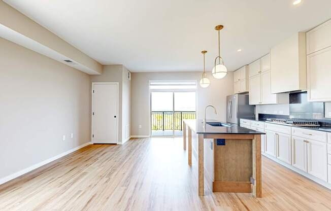 an open kitchen and living room with a wood floor