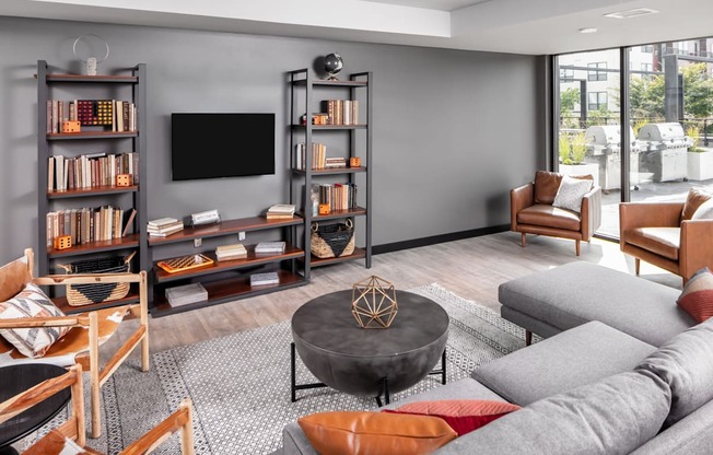A living room with a grey sofa, a black coffee table, and a television on a stand.